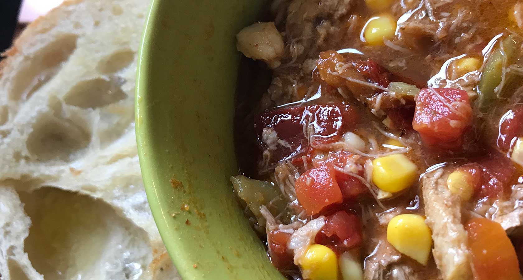 Close-up of veggie stew with piece of crusty bread.