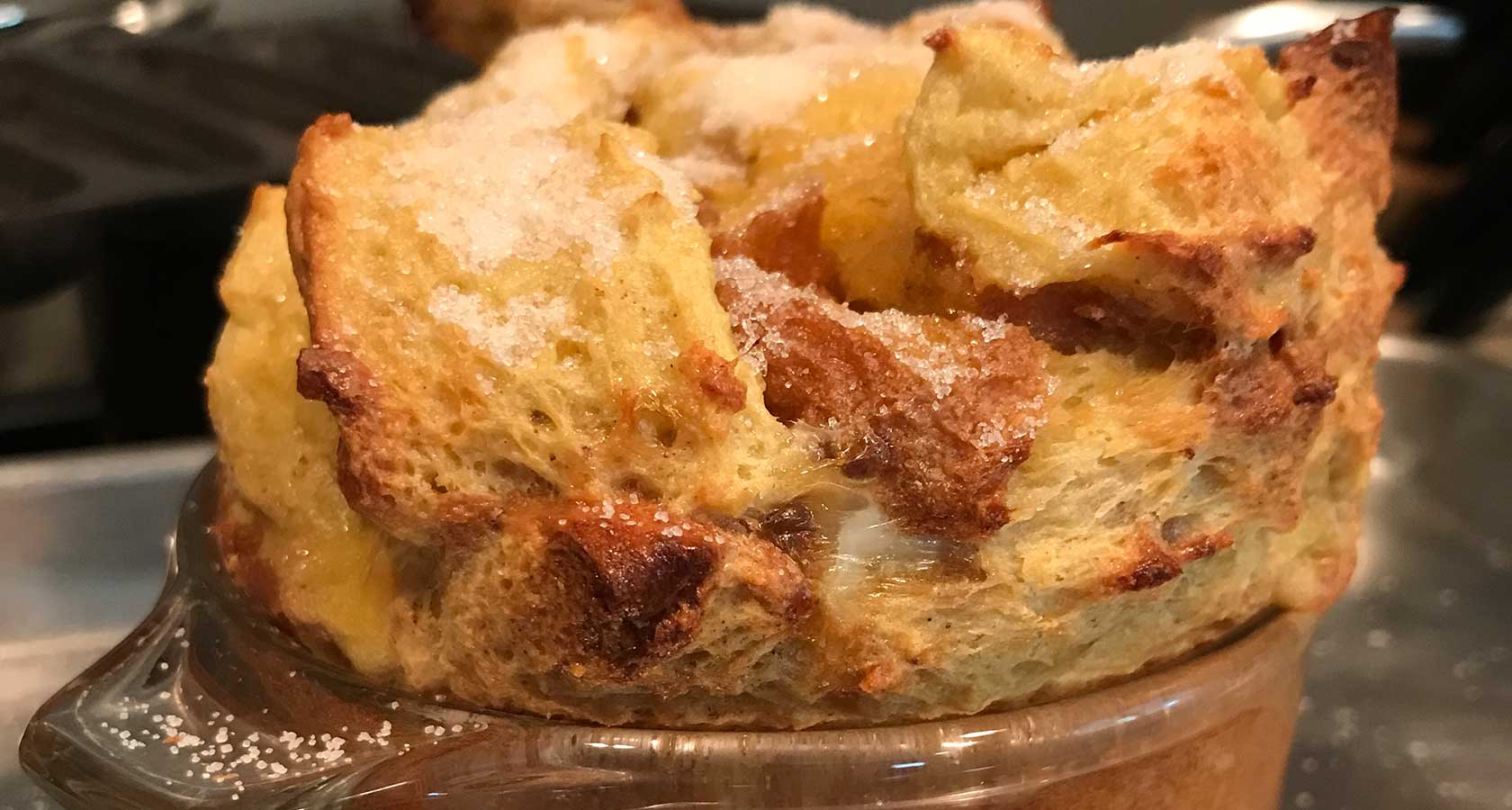 Baked French toast popping up out of glass soufflé baking dish.