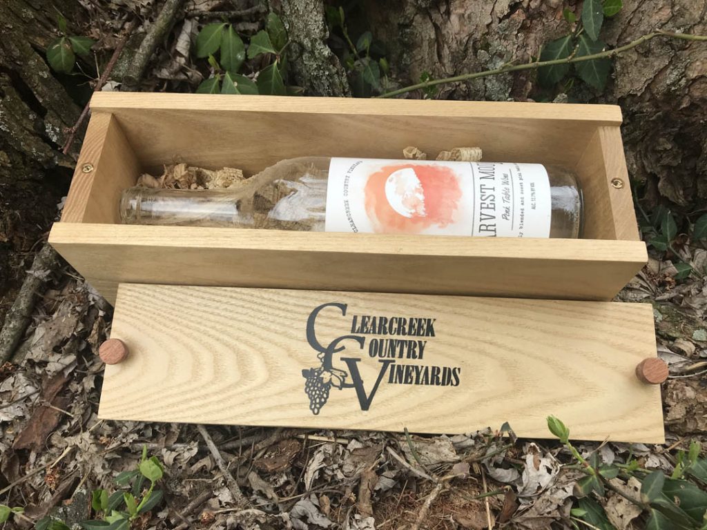 Custom-made wooden box holding bottle of wine with sliding lid removed