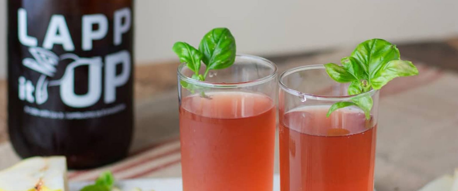 Growler of Lapp It Up Kombucha next to two glasses of kombucha