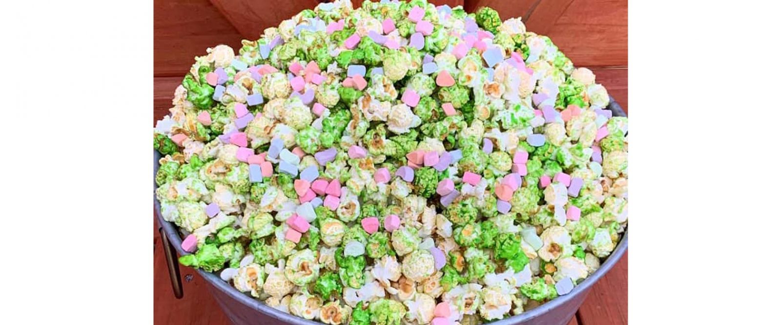 Pastel-colored popcorn in bucket with multi-colored marshmallow bits