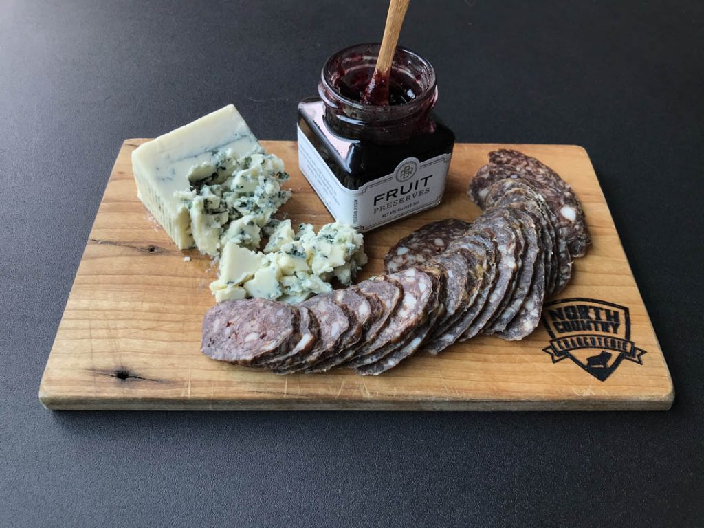 North Country Charcuterie Feeling Blue Board with jam, blue cheese and sliced meat.