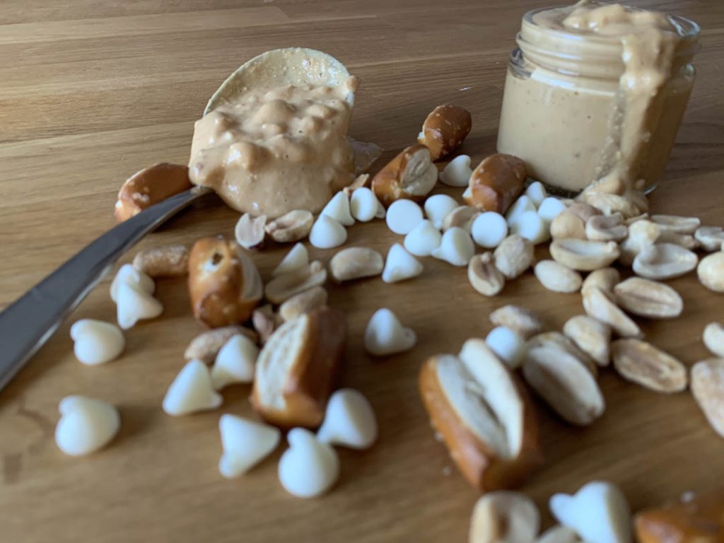 Spoonful of Peanut Butter & Jenny peanut butter with scattered white chocolate chips and pretzels