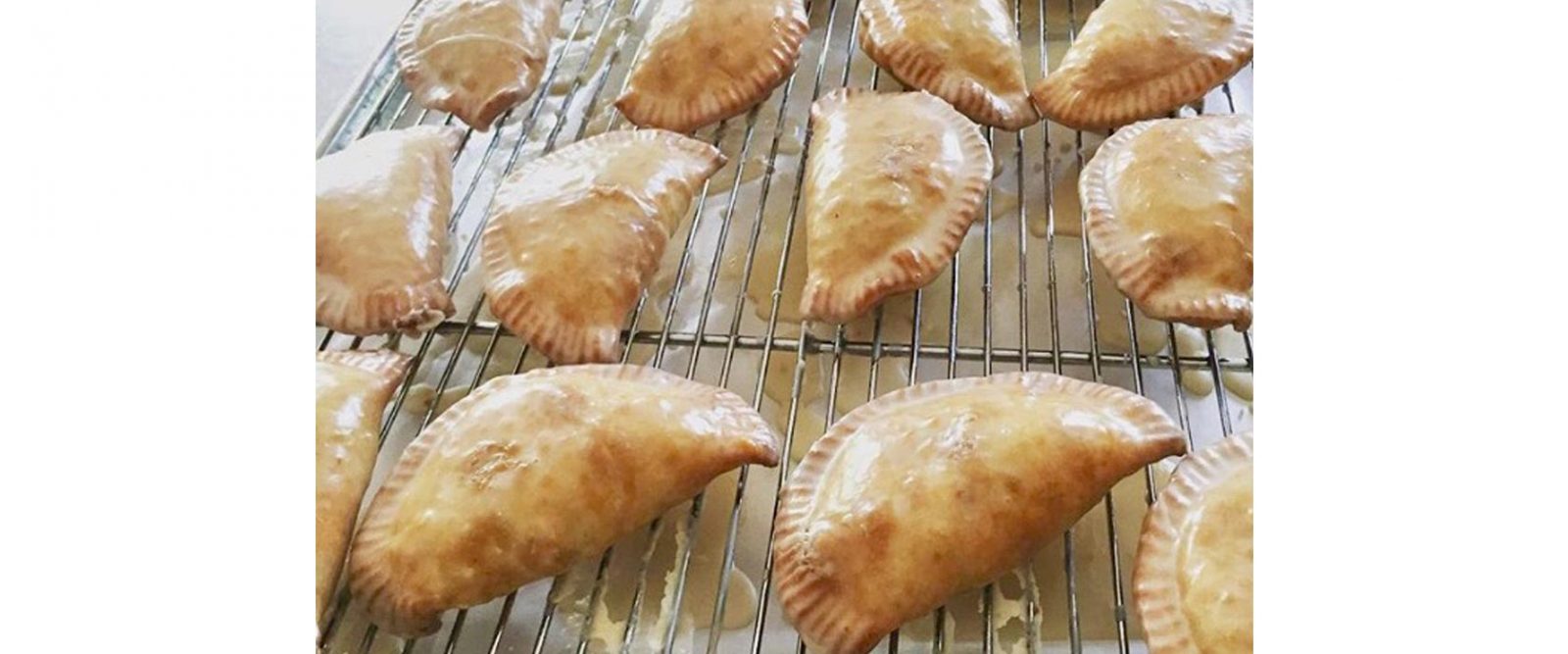 Just baked fruit hand pies resting after icing on wire racks