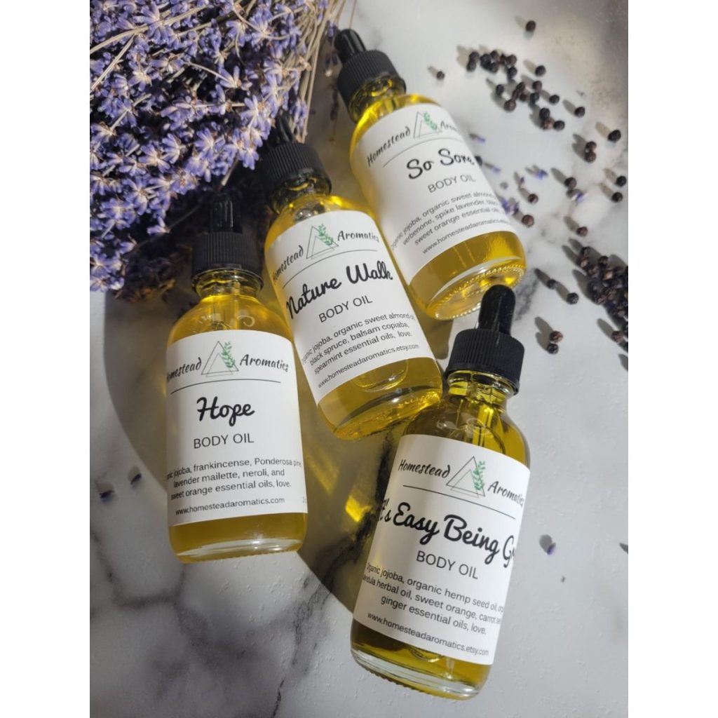 four bottles of aromatherapy body oils with lavender sprig