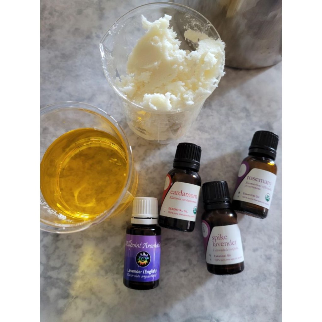 four small bottles of essential oils with two cups of other base oil ingredients