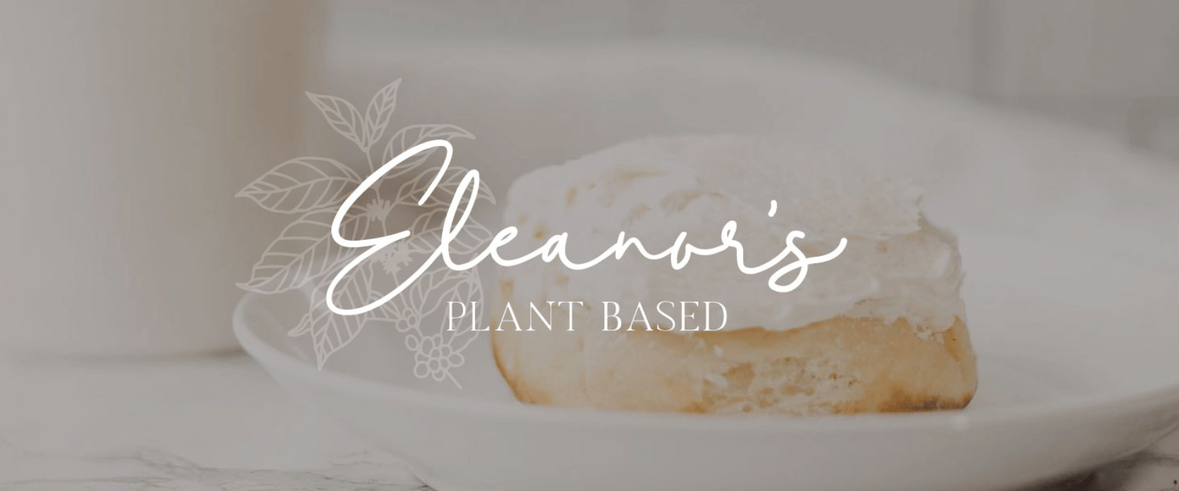 Eleanor's Plant Based logo in white script over image of a frosted cinnamon roll