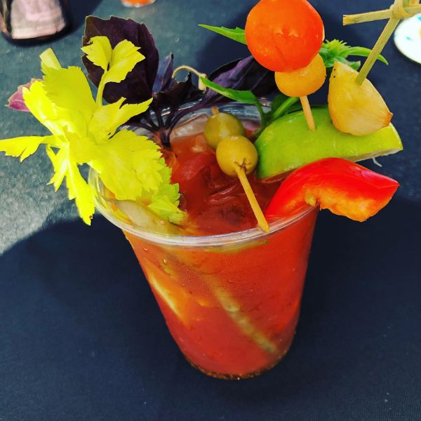 cup with bloody mary and lots of garnishes around the rim