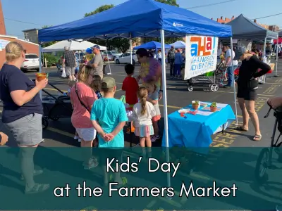 Kids at a blue pop up tent in a parking lot